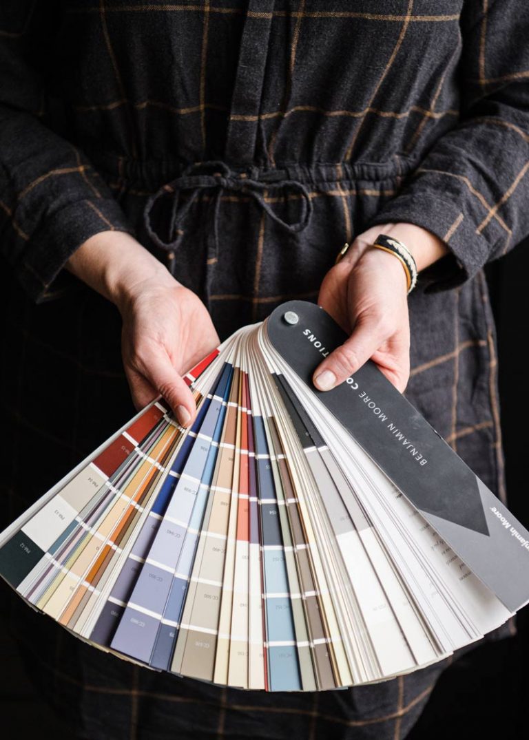 Hands fanning out paint color samples