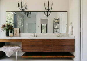 Large, custom, and walnut vanity with plenty of storage and natural lighting.