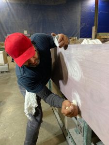 A Trim Tech Designs artisan finishing a custom cabinet piece using the cerusing method.